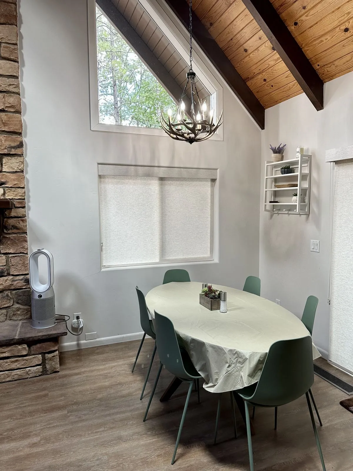 Dining table beneath an antler chandelier