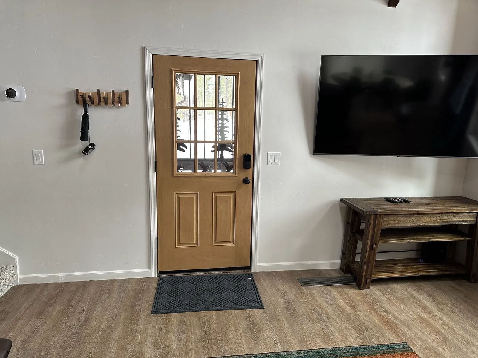Entryway with coat hooks and mounted TV