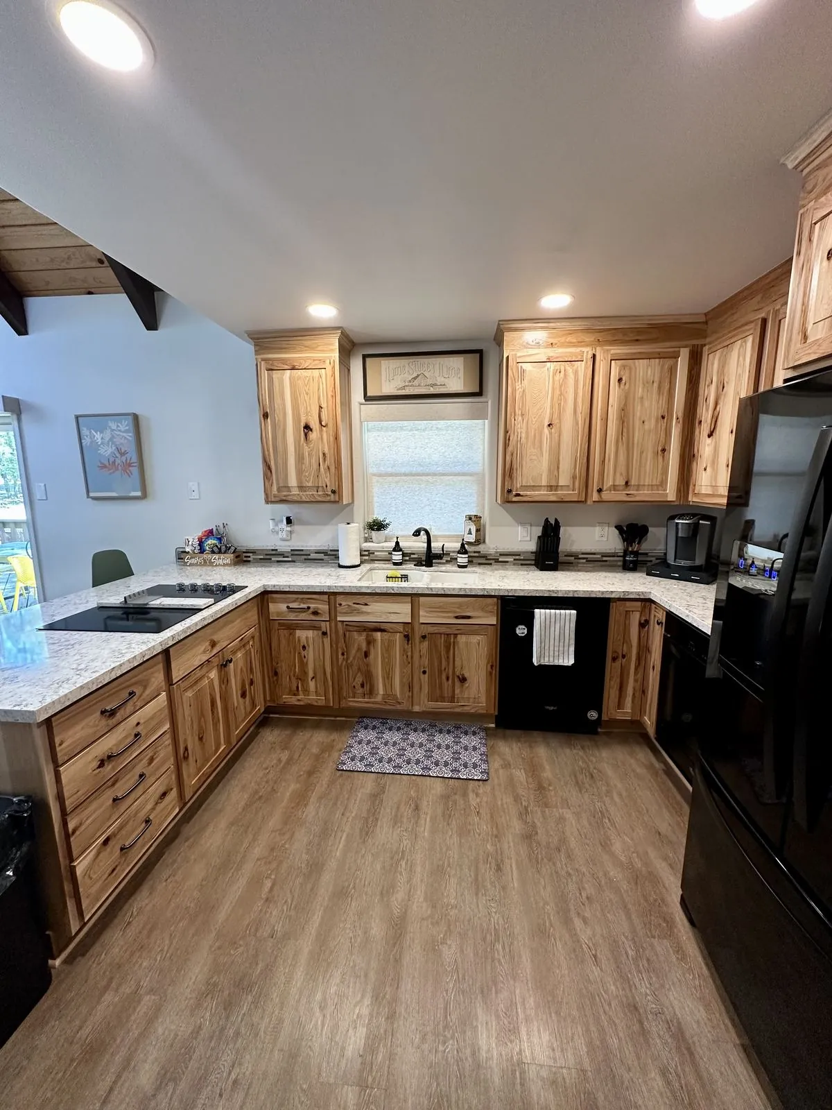 Kitchen sink, cabinetry, and black appliances