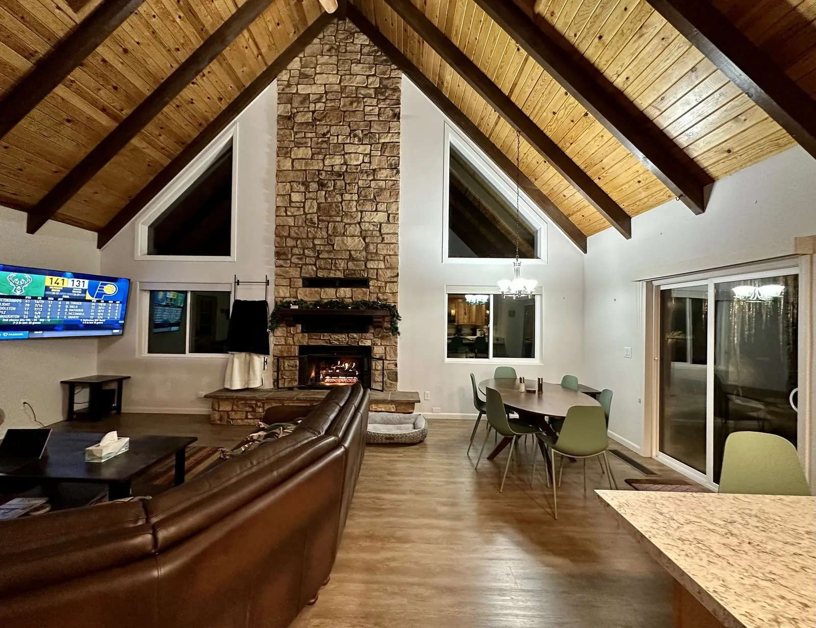 Living room with stone fireplace lit in the evening