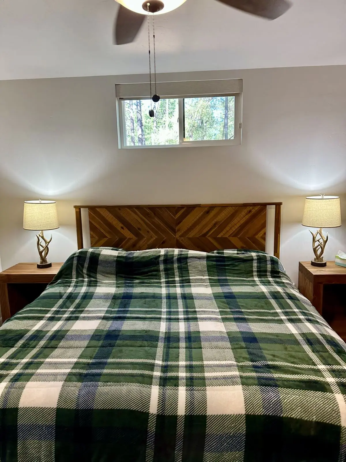 Primary bedroom with king bed and chevron wood headboard