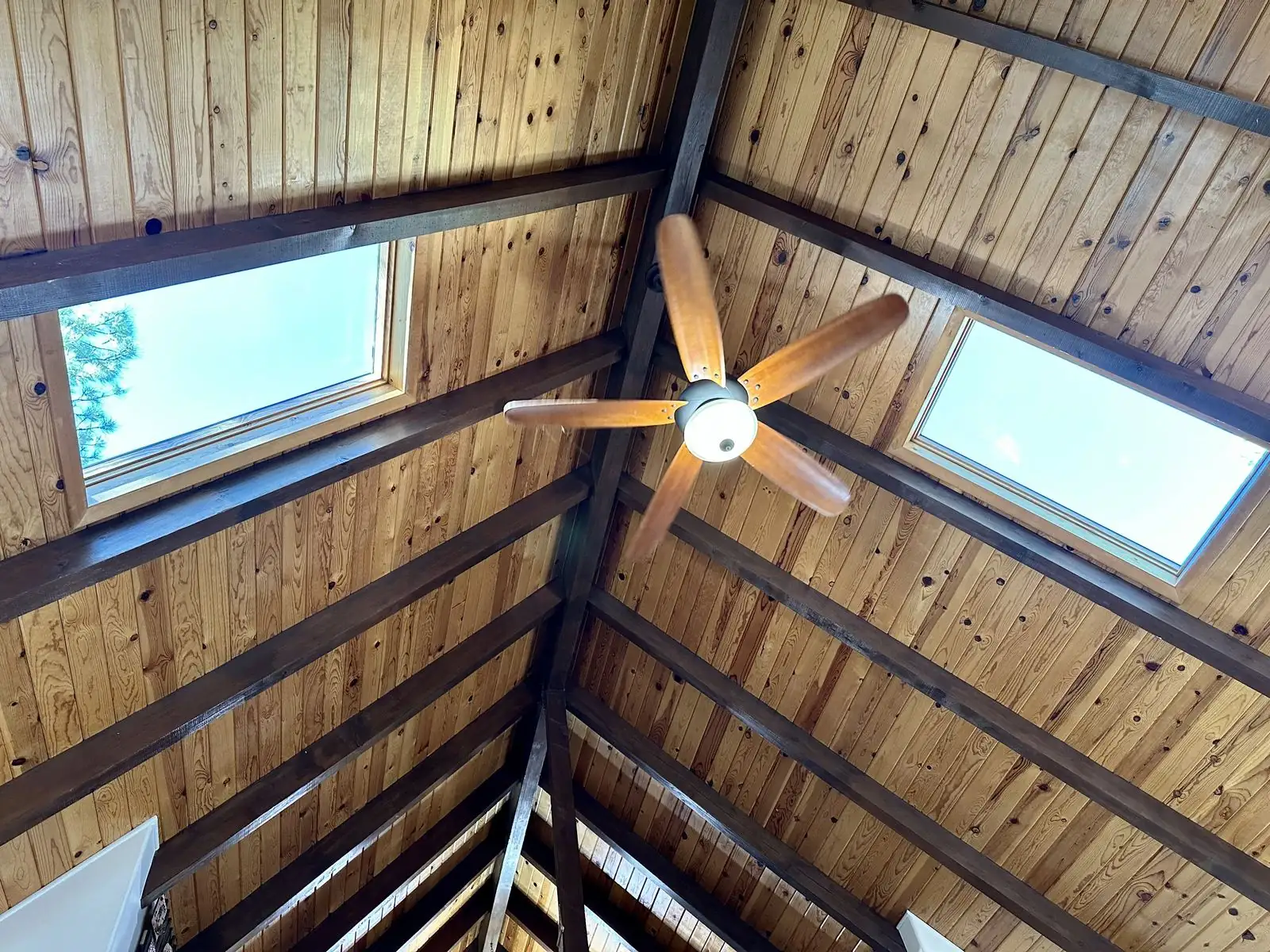 Vaulted wood ceiling with skylights and fan