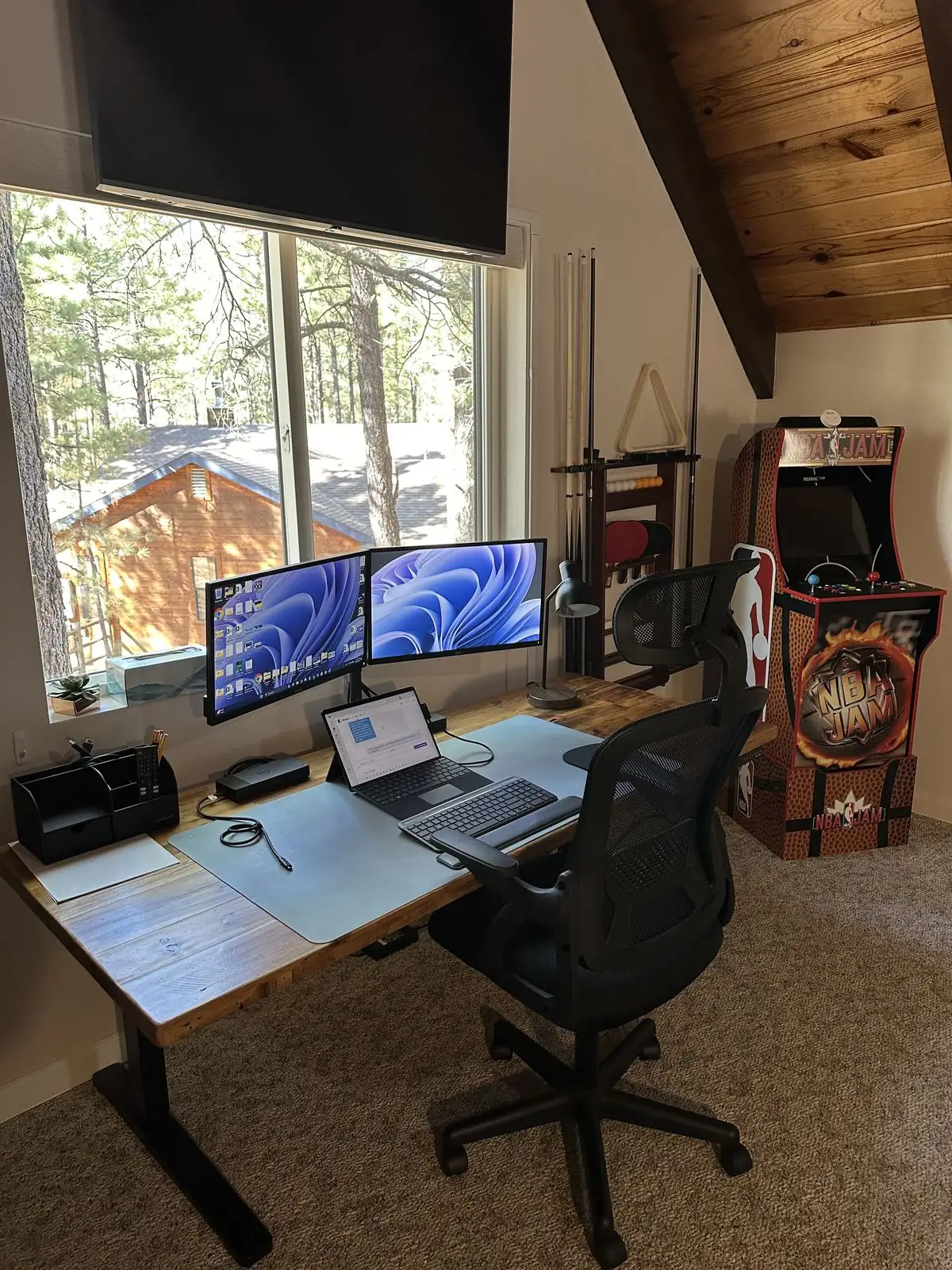 Work desk with dual monitors and NBA Jam arcade cabinet